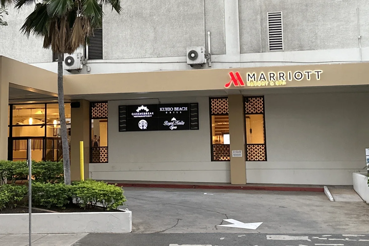 The street-level entrance of the Waikiki Beach Marriott Resort & Spa on Kalākaua Avenue, palm trees either side
